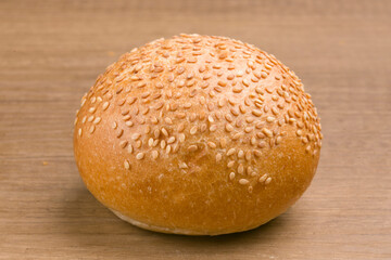 bun with sesame seeds on wooden background