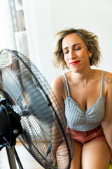 Woman refreshing with a fan during hot summer day