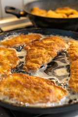 Crispy Breaded Chicken Filets Frying in a Hot Sizzling Pan