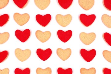 Heart-shaped cookies in rows isolated on white background. Heart-shaped cookies with red sugar paste alternating with plain cookies in top view. Love concept.
