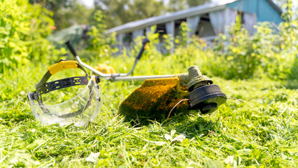 Lawn trimmer on a green lawn in front of the house