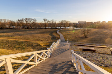 Fototapeta premium A long white wooden staircase leads up to a grassy hill