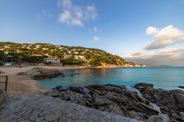 A beach with a rocky shoreline and a clear blue ocean