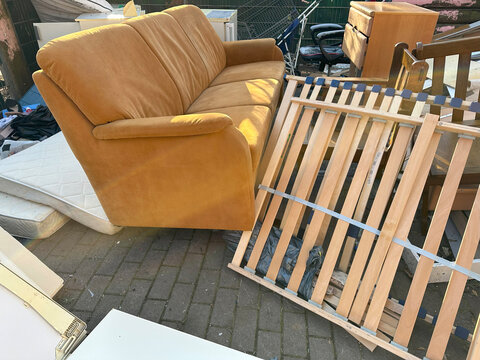 Discarded household items in messy pile on street, broken furniture, renovation, minimalism, and sustainability, collecting and recycling bulky waste to reduce environmental pollution