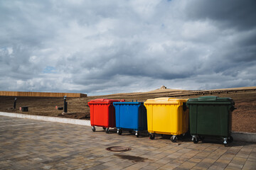 A vibrant and visually appealing row of colorful trash cans lines the busy sidewalk, creating an...