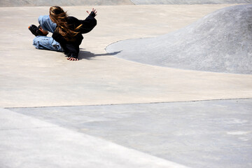 An unrecognizable girl takes a fall during an inline skating performance