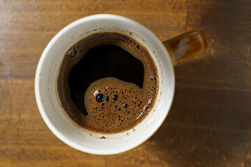 top view of coffee cup on wooden table, close up