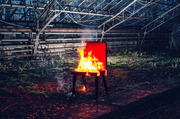Wooden chair is on fire. Incineration of furniture.