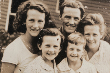 Retro family portrait from 1950 outdoors. Old faded black and white photo with worn-out edges