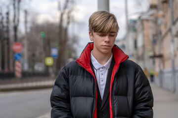 Pensive Moment: A Young Man's Contemplation on a City Street