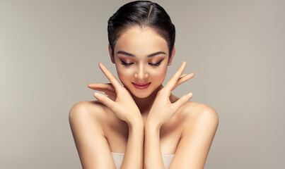 Beautiful young woman with clean fresh skin on face . Girl facial  treatment   . Cosmetology , beauty  and spa .