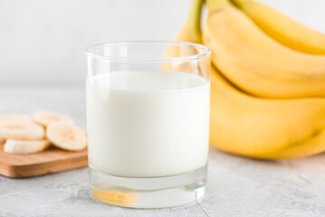 Banana milk in a glass on a light table. Traditional Korean drink.