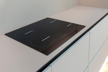 Four-zone induction hob on a matte beige kitchen countertop