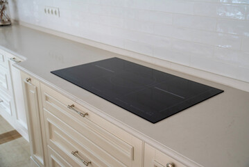 Induction hob on a light countertop with classic cream cabinets