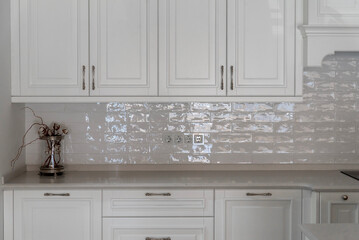 White kitchen cabinets with shiny brick tiles