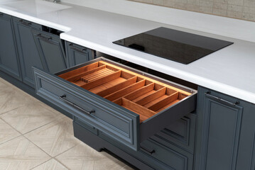 Open kitchen drawer with wooden cutlery organizer