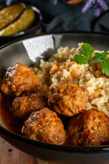 Meatballs pork and mashed potatoein paprika gravy served with groats bulgur.