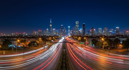 Fototapeta premium Cityscape Night Highway Lights - Stunning night cityscape with vibrant highway light trails leading towards a modern city skyline