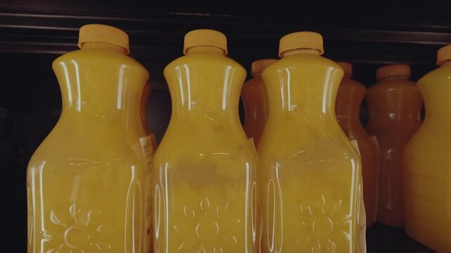 Fresh orange juice bottles neatly arranged on a grocery store shelf, showcasing vibrant colors and inviting packaging in a well-lit retail environment