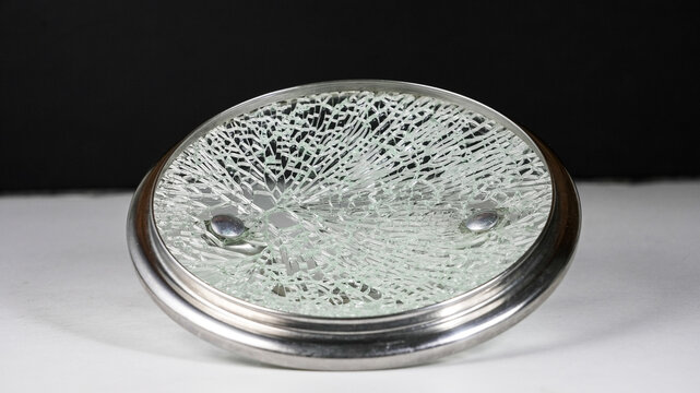Shattered glass  cover with intricate crack patterns lies on a dark background - Powered by Adobe