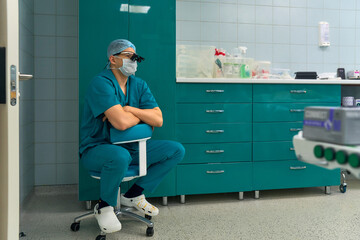 the doctor is sitting on a chair in the operating room