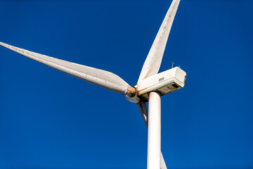 Wind turbine closeup isolated of windmill propeller against blue sky in West Virginia Canaan valley