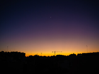 Crescent moon above city skyline at dusk © Stoca
