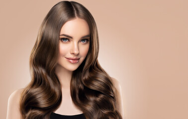 Beauty girl with long and shiny wavy hair . Beautiful woman model with curly hairstyle .
