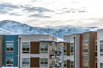 Avon, Colorado town in winter snow clouds mist blanketing view of Rocky Mountains and modern apartment architecture by Vail