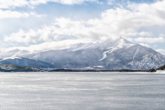 Silverthorne, Colorado Dillon Reservoir lake in snow winter season with blue water surface and peak One mountain with spruce trees forest
