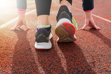  woman preparing to start on an athletics track