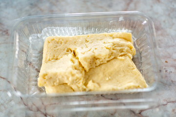 Famous local cheese from deli of market called Pljevaljski sir with macro view of texture of soft aged raw product