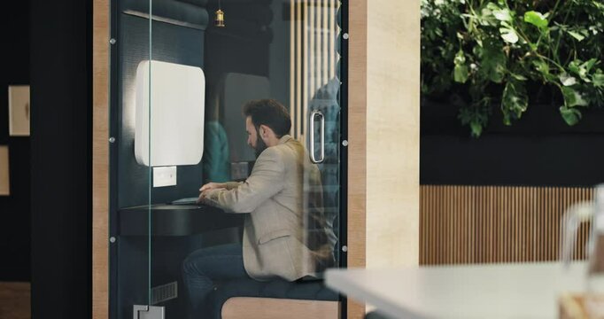 Office booth, business man and privacy, concentration and productivity boost. Soundproof pod, worker and open door of cubicle with focus space to reduce noise or distraction with tablet in workspace