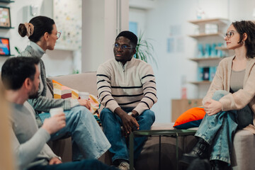 Naklejka premium Coworkers talking and discussing during informal meeting in office lounge