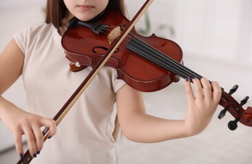 Teenage girl playing violin at music lesson, closeup