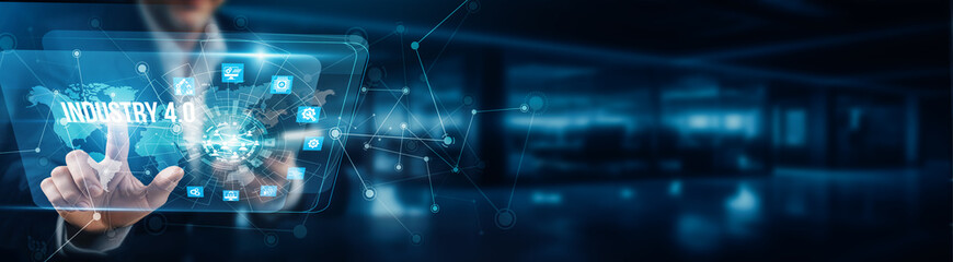 A businessman's hand is touching the virtual graphical interface of Industry 4.0 to enable smart manufacturing, integrate IoT, optimize supply chains, enhance automation, and improve productivity.