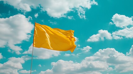 Bright yellow flag waving under a sunny sky with clouds arranged by the rule thirds, capturing the essence summer.