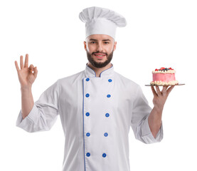 Happy confectioner in uniform holding delicious cake with berries and showing ok gesture on white background