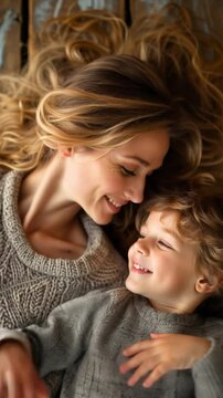 overhead shot close up mother embracing his son, enjoying the love of motherhood and childhood, lying down on a wooden floor mothers day childrens day