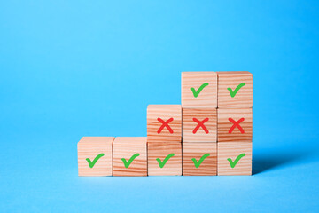 Approve of reject. Wooden cubes with check and cross marks on light blue background