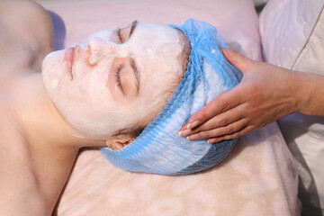 Fototapeta premium An experienced and responsible cosmetologist performs procedures on a patient's face in a beauty spa (from the series 