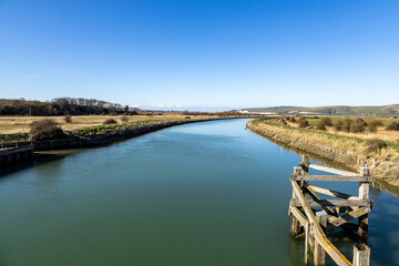 A view along the River Ouse in Sussex from Southease towards Lewes, with a blue sky overhead © lemanieh