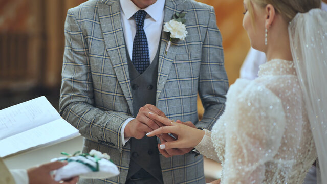 Wedding ring gliding onto finger, symbolizing eternal love and matrimonial bond between newlywed couple