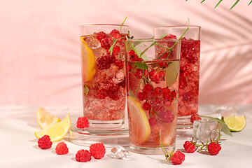 Modern still life with berry juice, raspberries, red currants, mint and oranges on elegant kitchen...