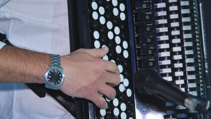 Musician's hand performing on vintage accordion, generating festive wedding music with passion and...