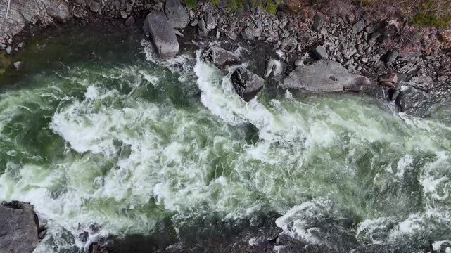 Aerial drone view of the rushing rapids in the white water of the Wenatchee river in Washington state. The Pacific Northwest nature is powerful, exciting, and dangerous. 