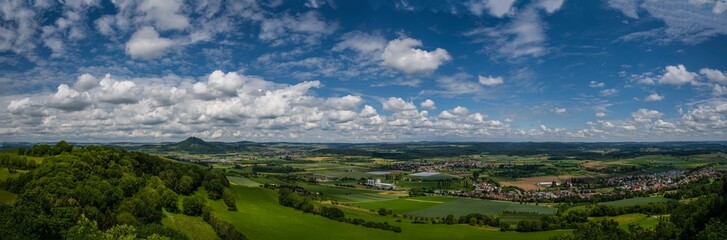 Vast green landscape under a blue sky filled with clouds captured during a sunny afternoon in the countryside