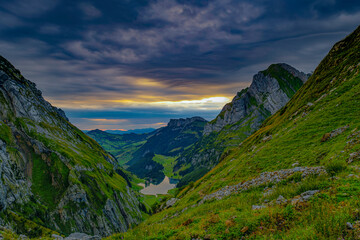 Majestic mountain landscape at dusk with vibrant sky and lush green valleys