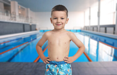 Cute little boy in trunks at indoor swimming pool