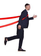 Happy businessman crossing red finish line ribbon on white background